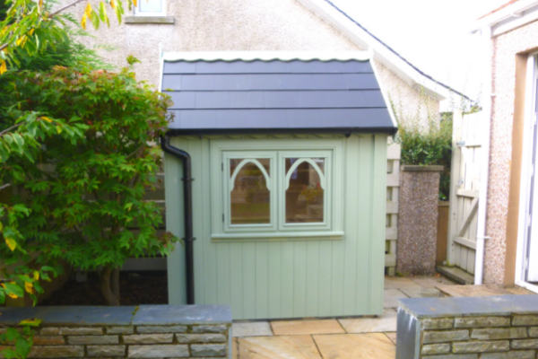 gothic style painted green shed with slate roof