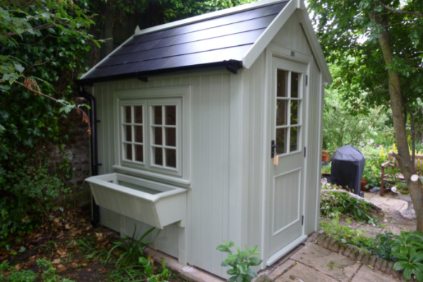 Pretty painted potting shed with slate roof